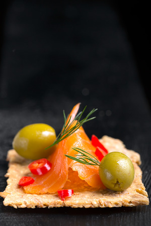 Snack with salmon, olives and dill on cerealsの写真素材