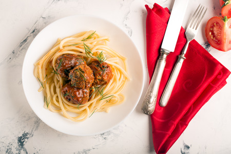 Meat balls in tomato sauce with pasta on a white backgroundの写真素材