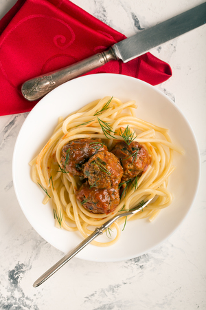 Meat balls in tomato sauce with pasta on a white backgroundの写真素材