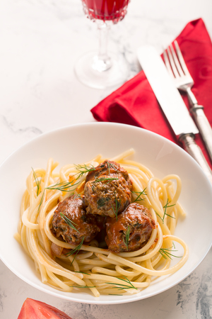 Meat balls in tomato sauce with pasta on a white backgroundの写真素材