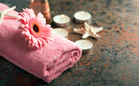SPA still life with towel, candles and gerberas flower on a dark wooden surfaceの写真素材