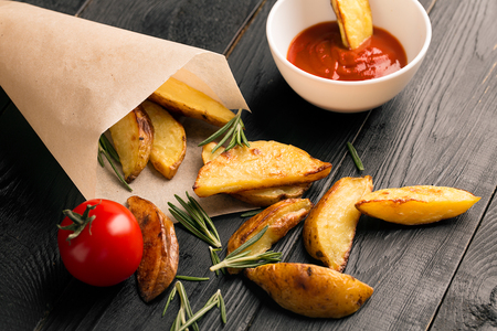 Fried potatoes with tomato sauce and rosemaryの写真素材