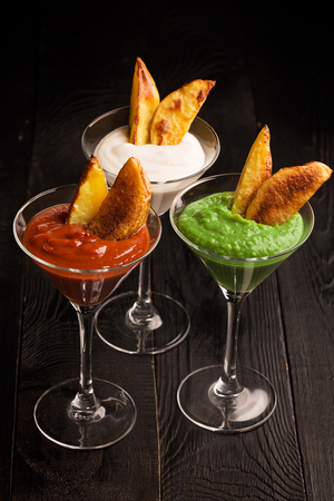 Fried potatoes with sauces (ketchup, pesto and yoghurt)の写真素材