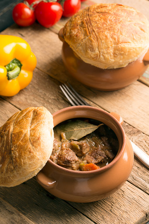 Irish pie with meat and vegetables on a wooden tableの写真素材