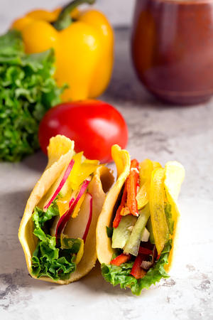 Taco with fresh vegetables on a grey surfaceの写真素材