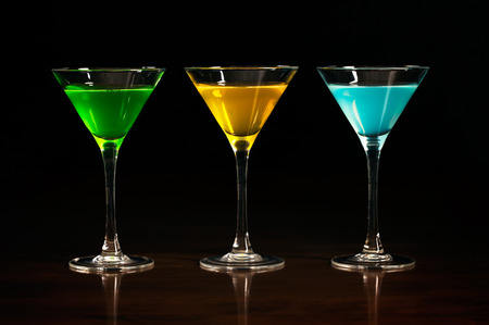 Three glasses of different alcohol cocktails on a black backgroundの写真素材