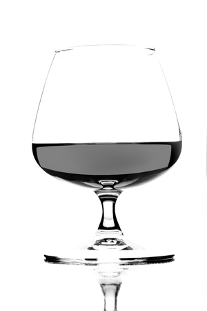 A glass of French brandy on a wooden table (black and white shot)の写真素材