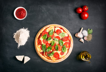 Pizza (margherita) and ingredients on the chalk board with copy spaceの写真素材