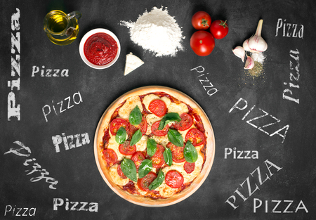 Ingredients of pizza on the chalkboard (tomatoes, cheese, sauce, water, spices, oil and flour). Prepared pizza. Inscriptions on the boardの写真素材