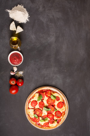 Ingredients for pizza on the chalkboard (tomatoes, cheese, sauce, water, spices, oil and flour). It has is a space for your text or pictureの写真素材