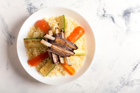 Traditional couscous dish with lamb ribs and vegetables. Top view. The image contains a copy space for your textの写真素材