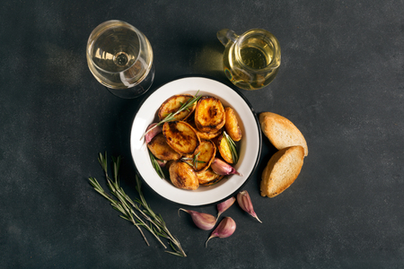 Baked potato with rosemary and garlic on the black chalkboardの写真素材