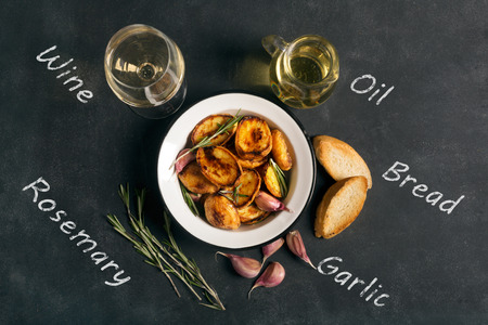 Baked potato with rosemary and garlic on the black chalkboardの写真素材
