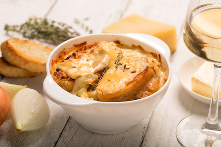 French onion soup with its ingredients on the white table (traditional cuisine)の写真素材