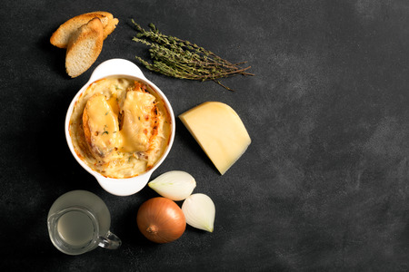 French onion soup on the black background with its ingredientsの写真素材