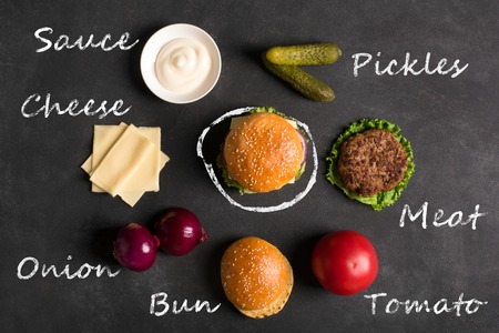 Beef burger with lettuce and minced meat cutlet. Black chalkboard. Top viewの写真素材