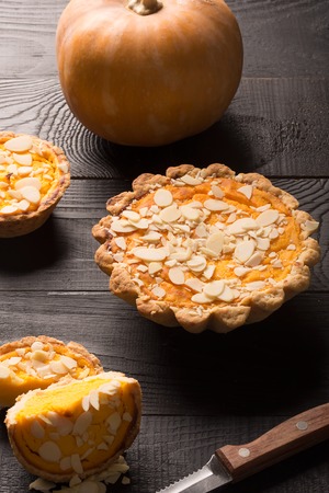 Pumpkin pie with almond slices on black rustic background, horizontalの写真素材