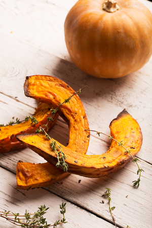 Baked pumpkin with theme on the white wooden table. Verticalの写真素材
