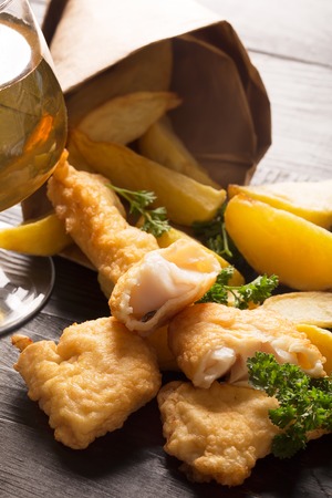 Traditional British fish and chips on the black background with glass of beerの写真素材