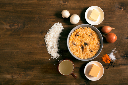 Risotto with mushrooms, fresh herbs and parmesan cheese. Wooden background, top viewの写真素材