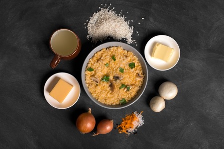 Risotto with mushrooms, fresh herbs and parmesan cheese. black chalkboard, top viewの写真素材