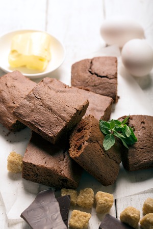Chocolate brownie cake and ingredients. White background. Close up shot, vertical orientationの写真素材