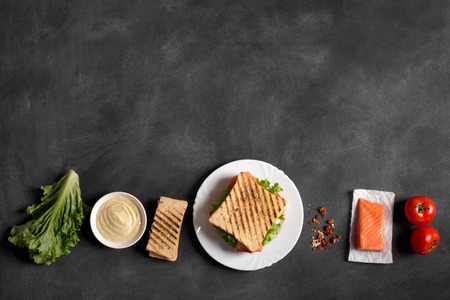 Club sandwich prepared with fish on the black chalkboard. Top viewの写真素材