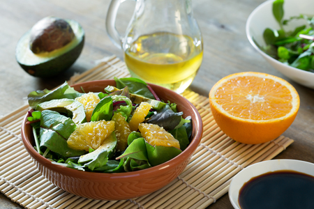 Fresh salad with avocado and orange, sprinkled with sesame seedsの写真素材
