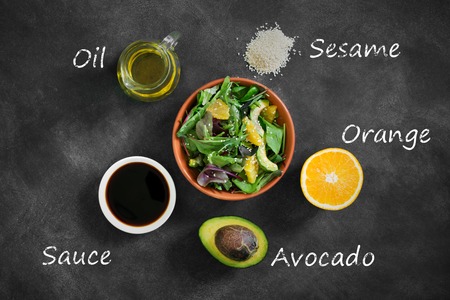 Fresh salad with avocado and orange, sprinkled with sesame seedsの写真素材