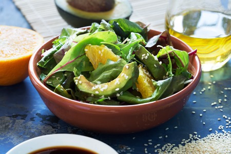 Fresh salad with avocado and orange, sprinkled with sesame seeds. Close up shotの写真素材