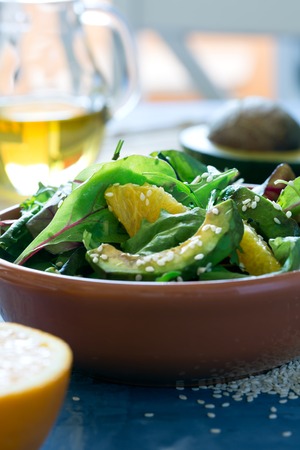 Fresh salad with avocado and orange, sprinkled with sesame seedsの写真素材