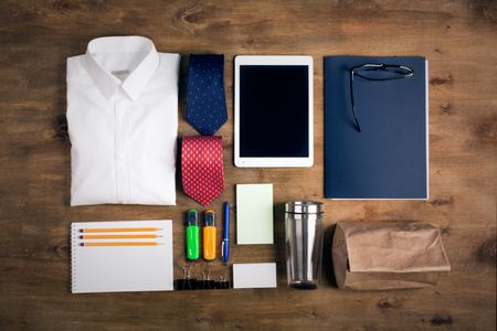 Business objects on the desk,including digital tablet, shirt, ties, lunch box, paper and pencils, top viewの写真素材