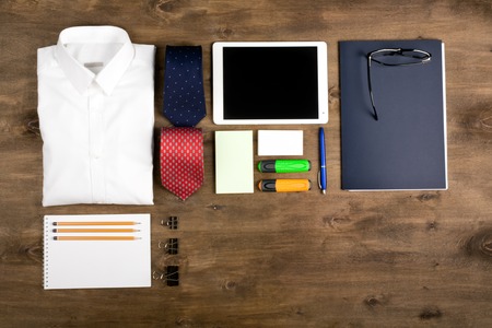 Business objects on the desk,including digital tablet, shirt, ties, lunch box, paper and pencils, top view with copy spaceの写真素材