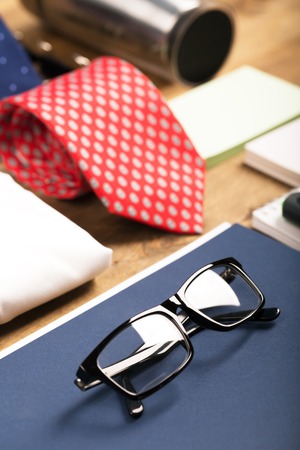 Business objects on the desk,including digital tablet, shirt, ties, lunch box, paper and pencils, top viewの写真素材