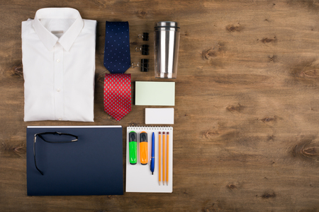 Business objects on the desk,including digital tablet, shirt, ties, lunch box, paper and pencils, top view with copy spaceの写真素材