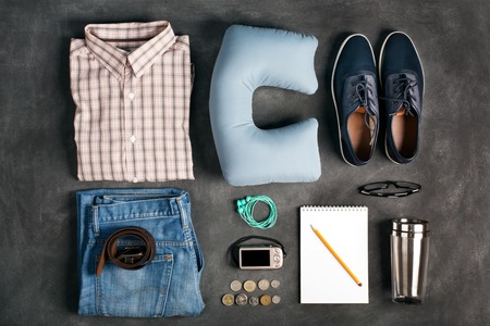 Vacation items on the table, top view.Clothing, shoes, camera and money as a travel elements. Black backgroundの写真素材