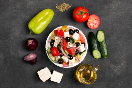 Greek salad ingredients: fresh vegetables, feta cheese and black olives on the chalkboardの写真素材