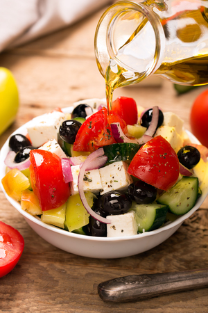 Greek salad : fresh vegetables, feta cheese and black olives in the white bowlの写真素材