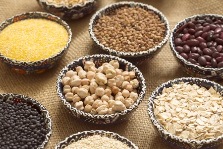 A selection of various colorful cereal on sackcloth in bowlsの写真素材