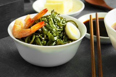 Delicious fresh seaweed salad with quail egg and seasame. Close upの写真素材