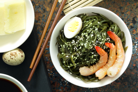 Delicious fresh seaweed salad with quail egg and seasame. Top viewの写真素材