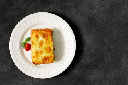 Traditional Italian lasagna made with minced beef bolognese sauce topped with melted cheese on the black background. Top viewの写真素材