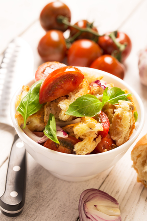 Italian Appetizer salad with tomatoes, bread,bazil mixed with lemon juice in the white bowlの写真素材