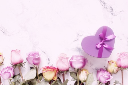 Purple and yellow roses, box present on white backgroundの写真素材