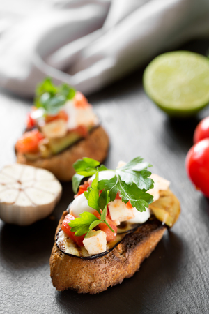 Tasty savory tomato Italian bruschetta, on slices of toasted baguette garnished with parsleyの写真素材