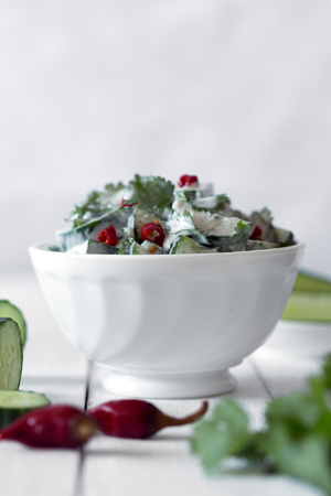 Cucumber salad with yogurt dressing and hot pepper on the white backgroundの写真素材