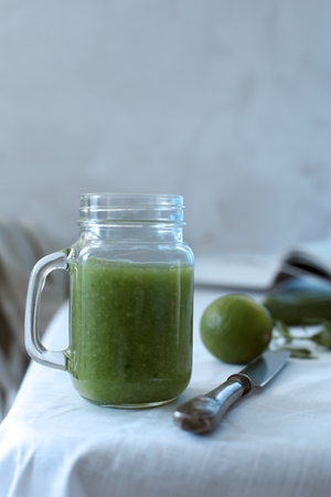 Fresh organic green smoothie with spinach, cucumber on a white tablewareの写真素材
