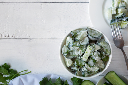 Cucumber salad with yogurt dressing on the white backgroundの写真素材