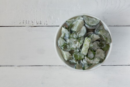 Cucumber salad with yogurt dressing on the white backgroundの写真素材