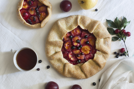 Traditional rustic cake prepared from dough and plum on the white tableclothの写真素材